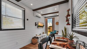 A dining area with a wooden table, chairs, and a TV mounted on the wall.