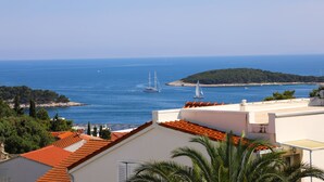 A coastal view with a clear sky, a sailboat, and a small island. - Stella Maris Hvar - Sea View Rooms with Balcony (Hvar)