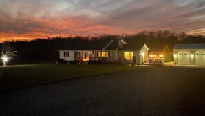 Uma casa com entrada por automóvel, garagem e um pequeno galpão.