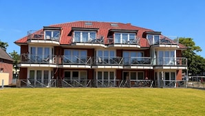 A multi-story building with balconies, large windows, and a flat roof. - Haus am Mühlenpark Whg. 8, Steinmarnerstr.77/79, 27476 Cuxhaven (Cuxhaven- Döse)