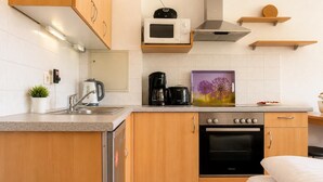 A compact kitchenette with a microwave, coffee maker, and a toaster. - Haus am Mühlenpark Whg. 8, Steinmarnerstr.77/79, 27476 Cuxhaven (Cuxhaven- Döse)