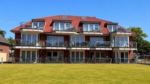 Ein mehrgeschossiges Gebäude mit Balkonen, großen Fenstern und einem flachen Dach.