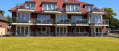 A multi-story building with balconies, large windows, and a flat roof.
