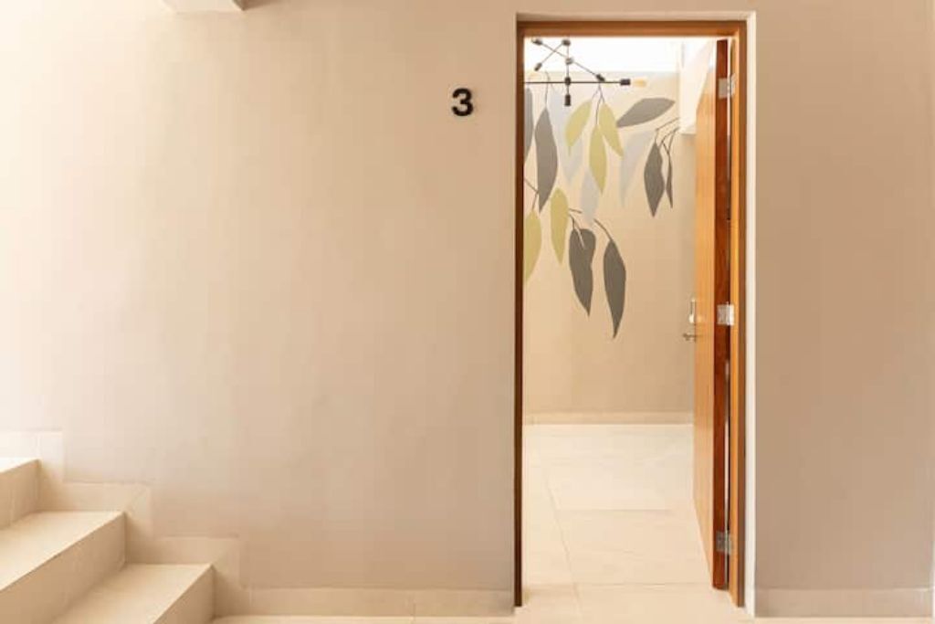 A hallway with a staircase leading to a room marked with the number 3.