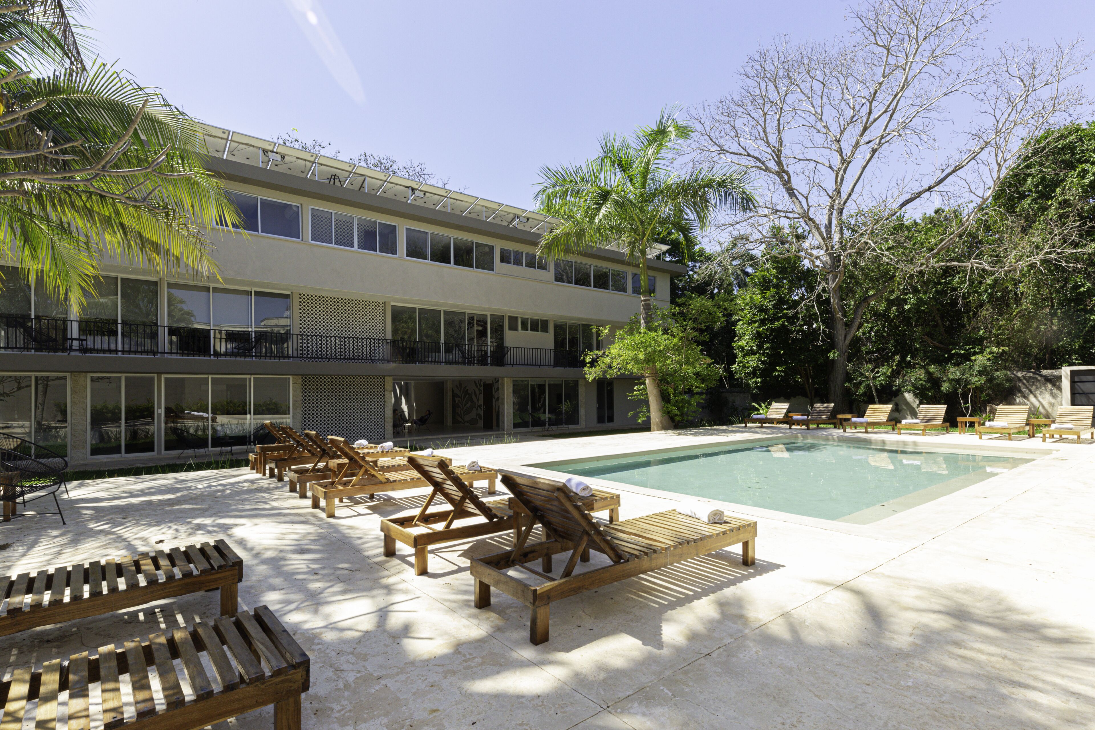 A pool area with wooden loungers and a clear view of the pool.