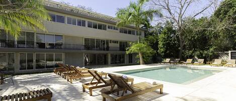 A pool area with wooden loungers and a clear view of the pool.
