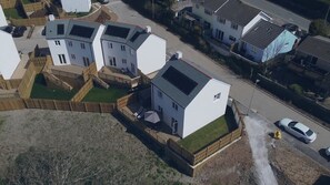 Homes with flat roofs and white exteriors are surrounded by fences in this quiet neighborhood.