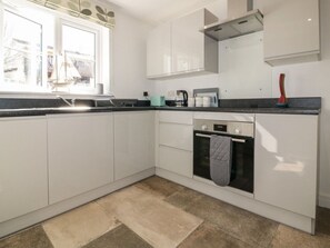 Enjoy a meal with a view from this kitchen, featuring an oven and stainless steel range hood.