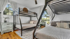 Dormitorio con literas, una mesita de noche y una ventana.