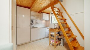 A compact kitchen with white cabinets, a wooden ladder, and a small table labeled 'Bread'. - Mezzanine Stylish Apartment Q by Vacationy (Porto)