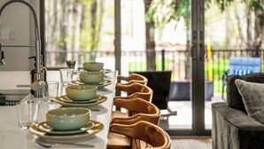 A dining area with a long table, chairs, and a view of the outdoors.