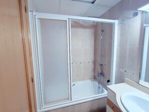 A bathroom with a glass-enclosed shower, a white bathtub, and a sink. - Costa Norte Vinaros (Vinaròs)
