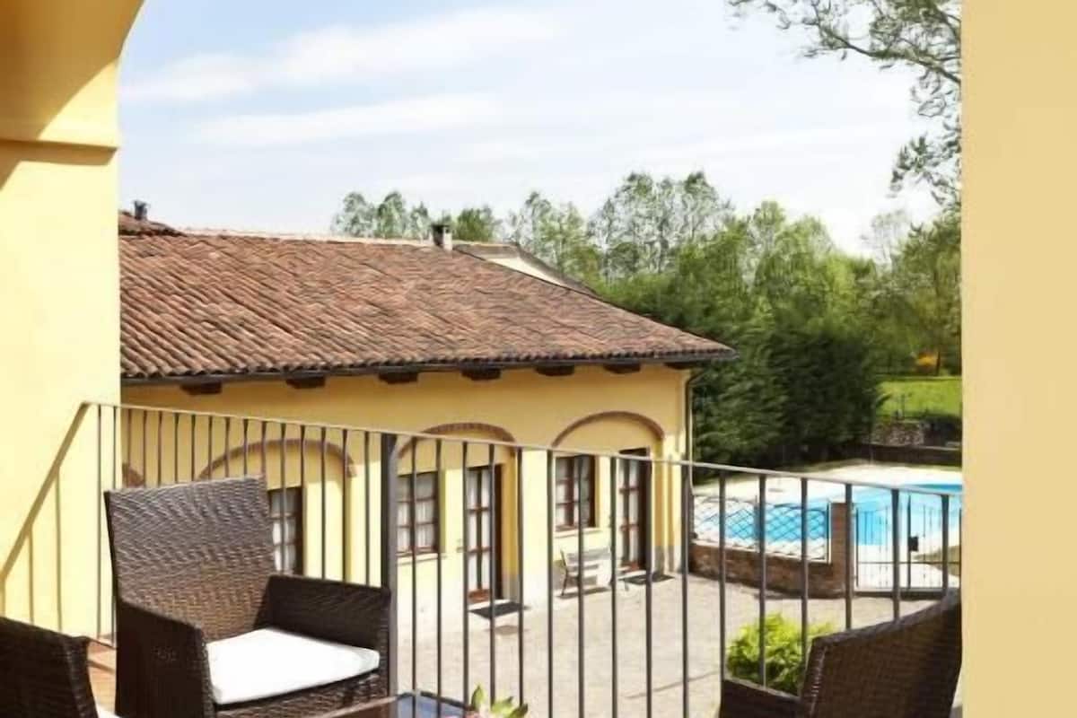 A patio with wicker furniture and a view of a swimming pool.