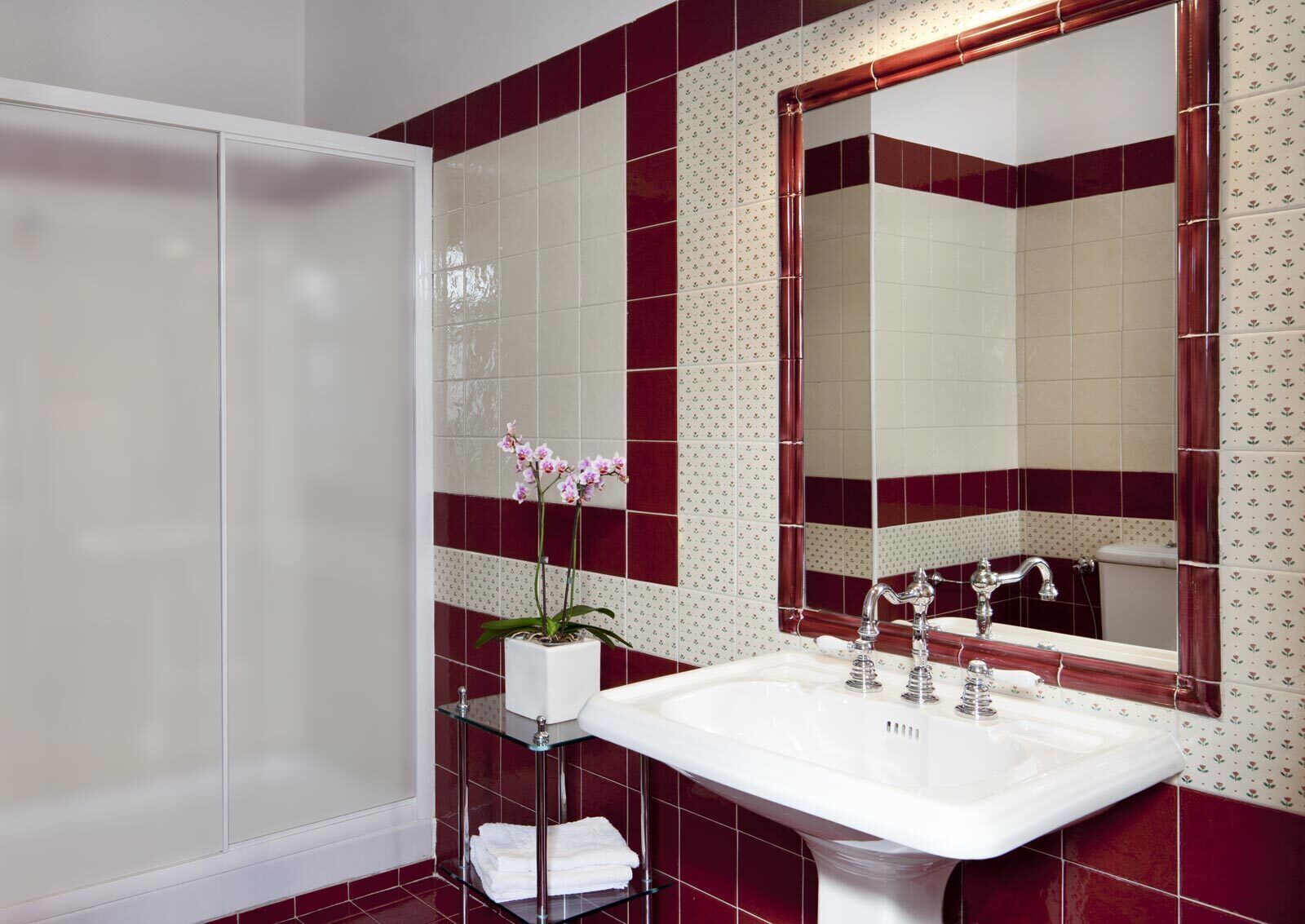 A bathroom with a white sink, a mirror, and a shower.