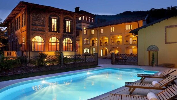 A large, multi-story building with a swimming pool and sun loungers. - Villa Soleil  (Colleretto Giacosa)