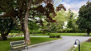 A park with a gravel path, a bench, and a lamp post. - Villa Soleil  (Colleretto Giacosa)