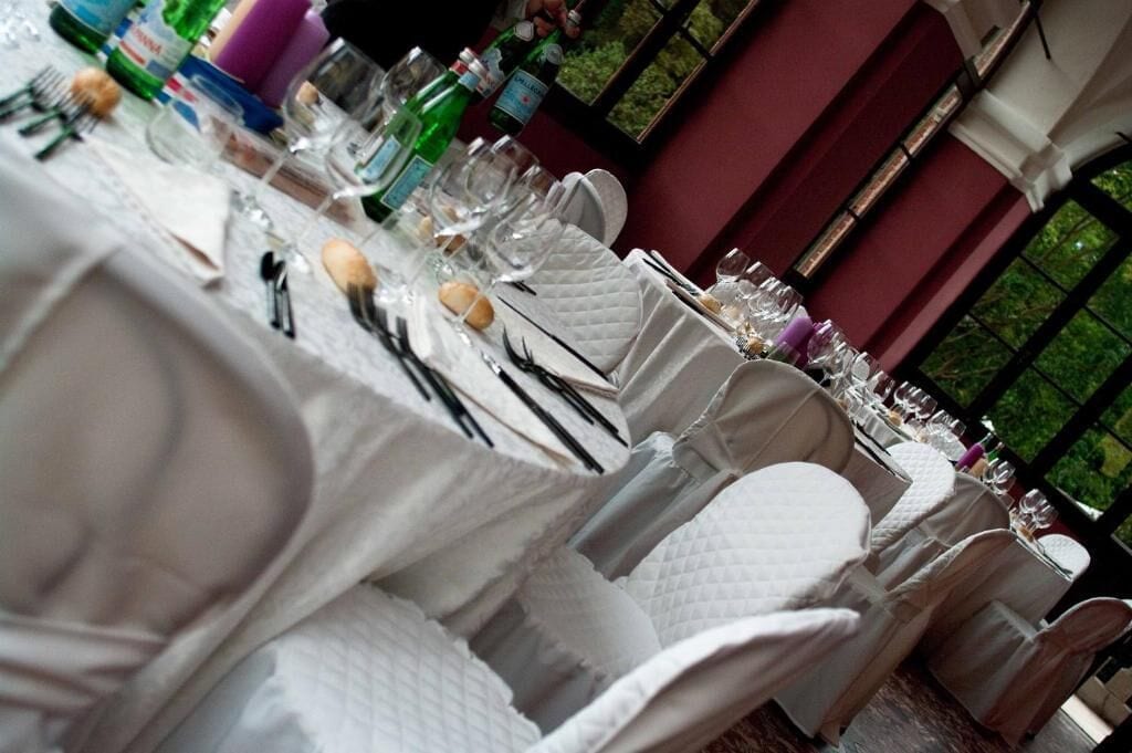 Une table dressée pour un repas formel, avec des nappes blanches, de la verrerie et des couverts disposés avec soin.