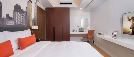 Une chambre d’hôtel moderne dotée d’un grand lit, d’un bureau, d’une chaise, d’un miroir et d’une décoration murale représentant un paysage urbain.