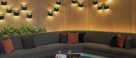 Una sala moderna con un sofá modular, una mesa de centro y una alfombra de diseño geométrico.