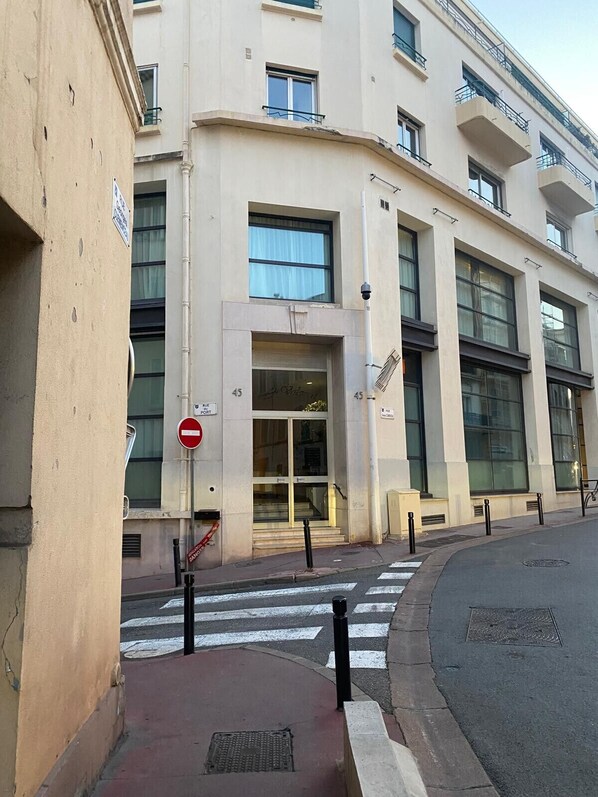 A multi-story building with large windows and a ground-level entrance. - STUDIO LUMINEUX 200 m DES PLAGES A0B192 (Cannes)