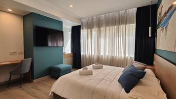 Una habitación de hotel moderna con una cama grande, un escritorio y una silla cómoda.