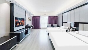 A modern hotel room with a large bed, a desk, a TV, and a view of the city.