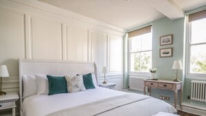 A bedroom with a large bed, bedside tables, a nightstand, a dresser, and a window with a view. - The Admiral's Home (Whitehaven)