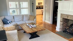 Una sala de estar con sofá, mesa de centro y chimenea.