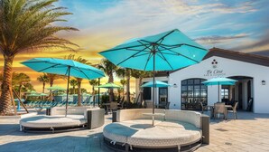 Zona de piscina con sillones de descanso, sombrillas y un bar/lounge llamado "Ti Casa".