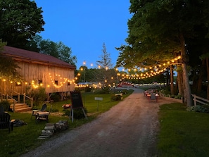 A rustic barn with a dirt path leading to outdoor seating.