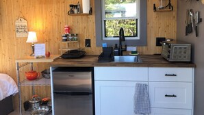 A compact kitchen with a built-in sink, a toaster, and a refrigerator.
