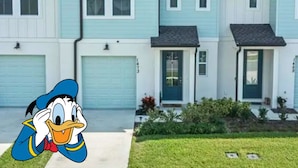 Una hilera de casas de dos pisos con revestimiento azul claro y techos oscuros.