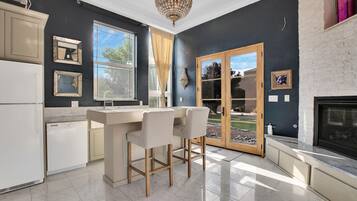 Eine moderne Küche mit Bar, großen Fenstern und Kamin.