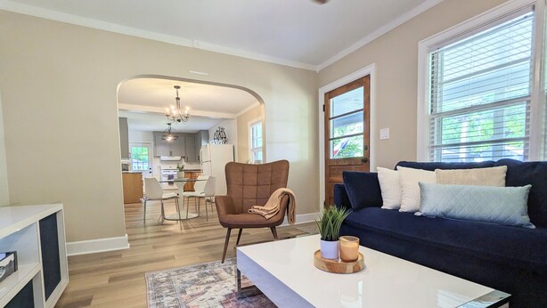 A modern living room with a dark blue sofa, a white coffee table, and a patterned rug. - Center of Wilmington-Zen on 42nd-fully fenced yard-Pets ok (Wilmington)