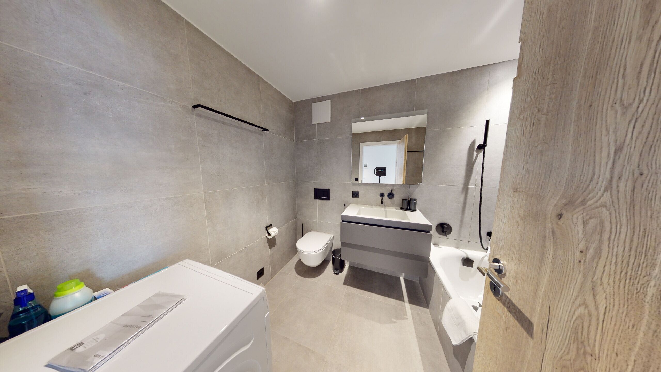 Un baño moderno con inodoro, lavamanos y ducha.
