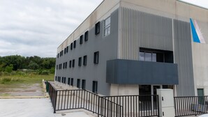 A modern building with a flat roof, multiple windows, and a gated entrance. - ESTRELA DO CAMIÑO (Palas de Rei)