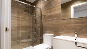 A modern bathroom with a glass-enclosed shower, a toilet, and a sink with a mirror above. - ESTRELA DO CAMIÑO (Palas de Rei)