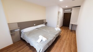 A bedroom with a bed, a nightstand, a wall-mounted shelf, an air conditioning unit, and a door leading to another room. - ESTRELA DO CAMIÑO (Palas de Rei)