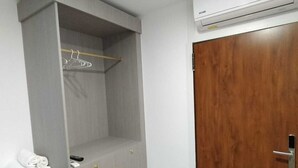 A room with a grey wardrobe, a wooden door, and an air conditioning unit. - ESTRELA DO CAMIÑO (Palas de Rei)