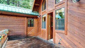 A wooden cabin with a large door, windows, and a metal roof. - Deck w/ New Hot Tub (Old Pic): Large TD Home (Truckee)