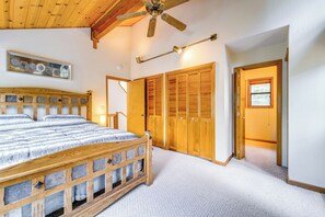 Ein Schlafzimmer mit einem hölzernen Bett, Schränken und einem Deckenventilator.