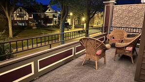 A balcony with wicker chairs and a patterned wall. - The Antique Reno is walking distance to the Falls and in a historic area. (Niagara Falls)