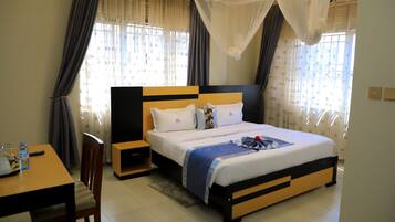 A bedroom with a bed, bedside tables, a chair, and curtains.