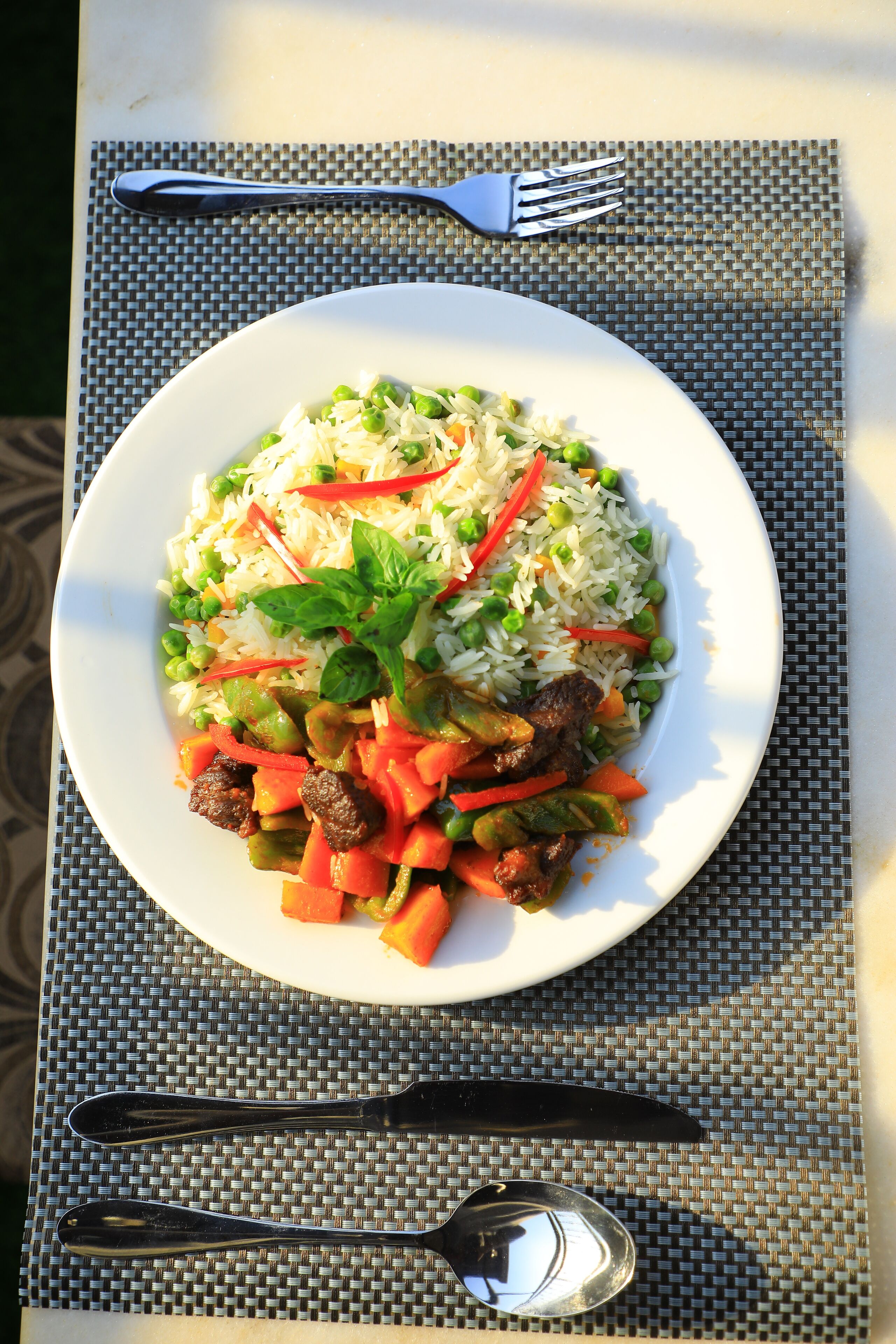 Une assiette de nourriture sur une table, avec une fourchette et une cuillère.