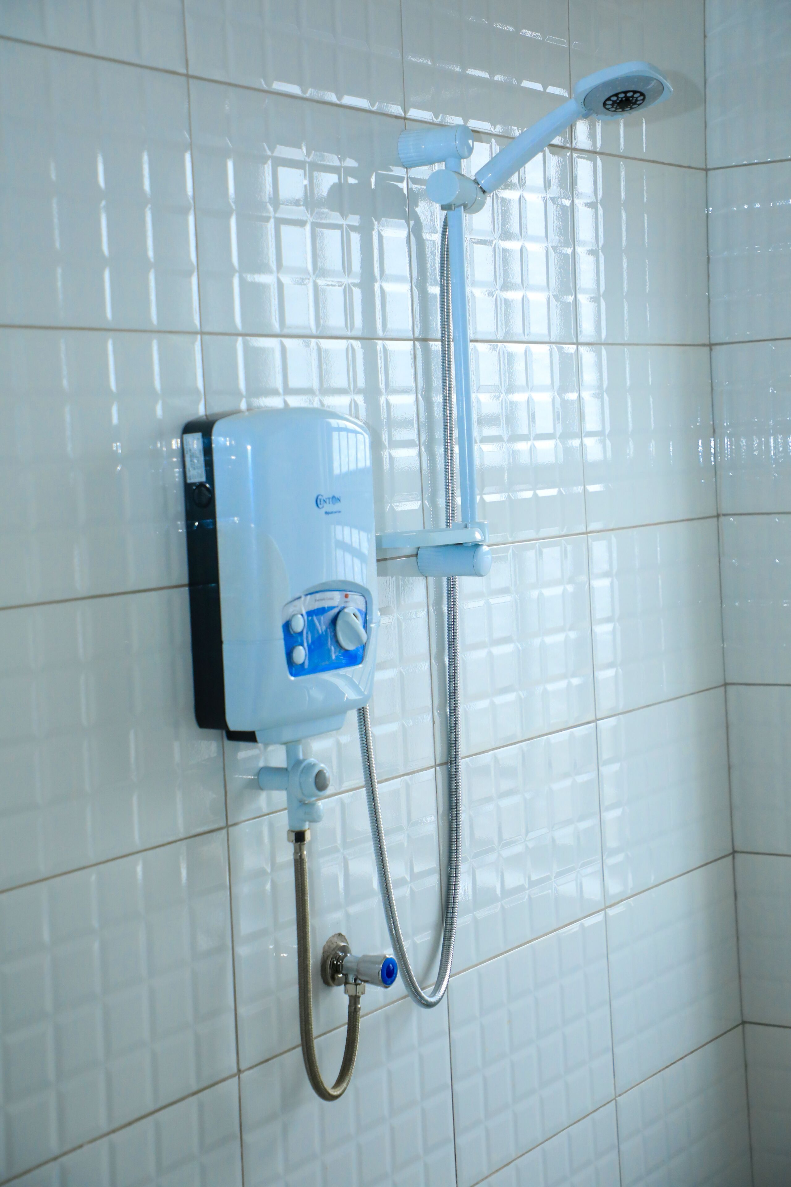 A wall-mounted shower unit with a control panel and a handheld showerhead.