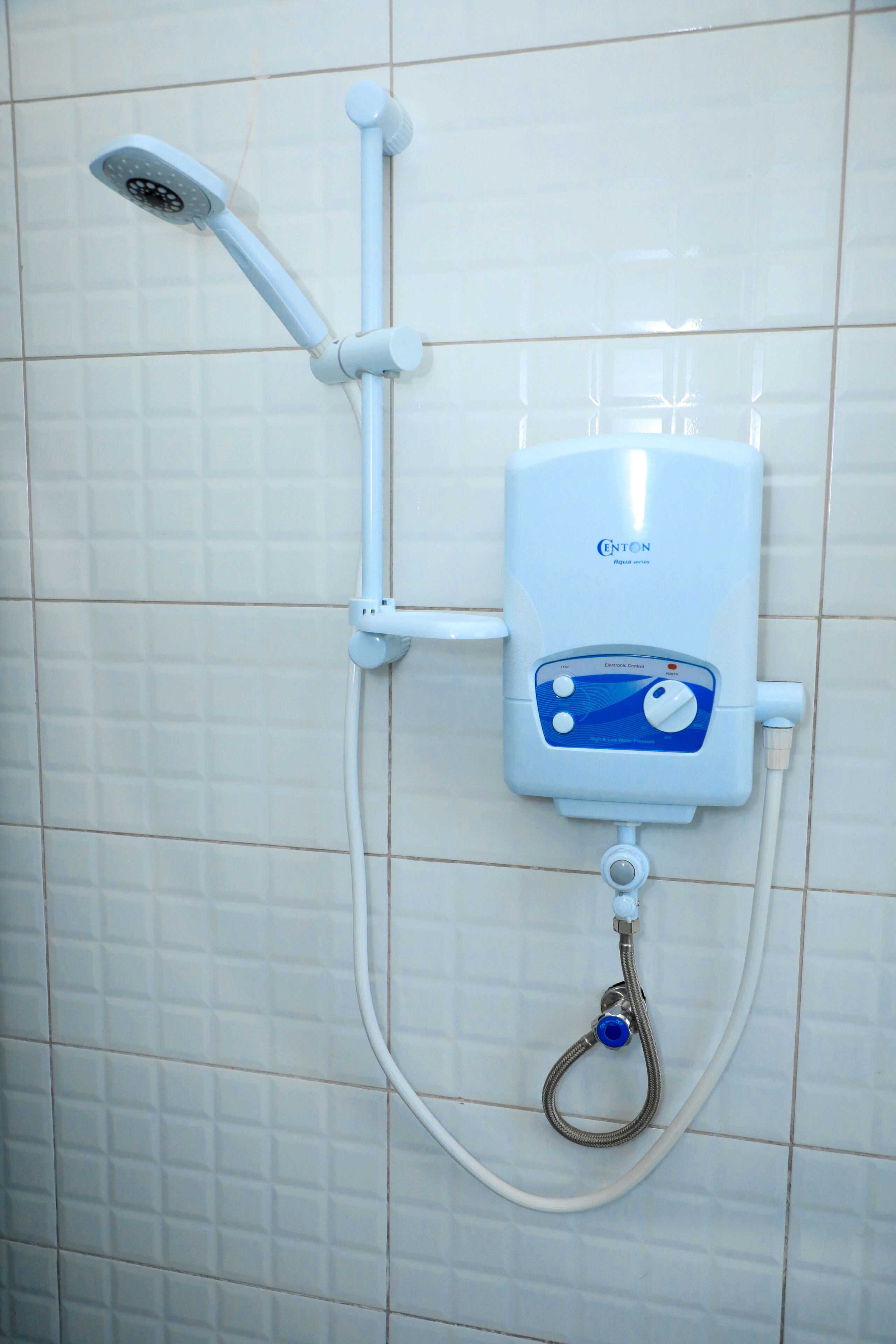 A wall-mounted shower unit with a control panel, a handheld showerhead, and a flexible hose.