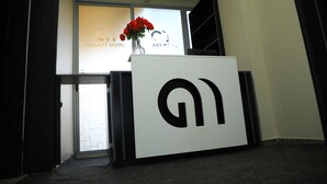 Un comptoir d’accueil orné d’un logo, un vase rempli de fleurs rouges et une enseigne indiquant le nom du Galaxy Motel.