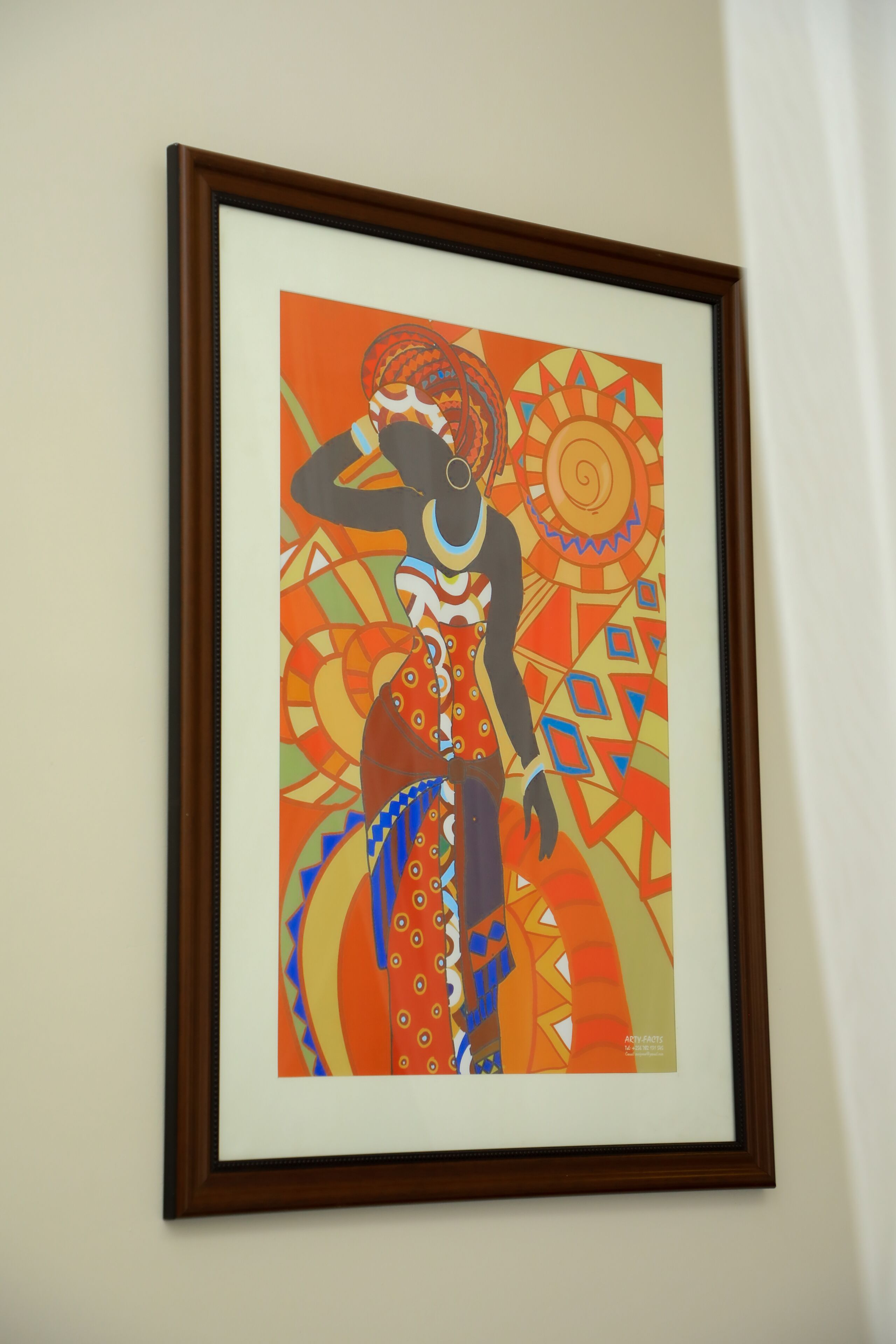 A framed abstract artwork with geometric patterns and a central figure.