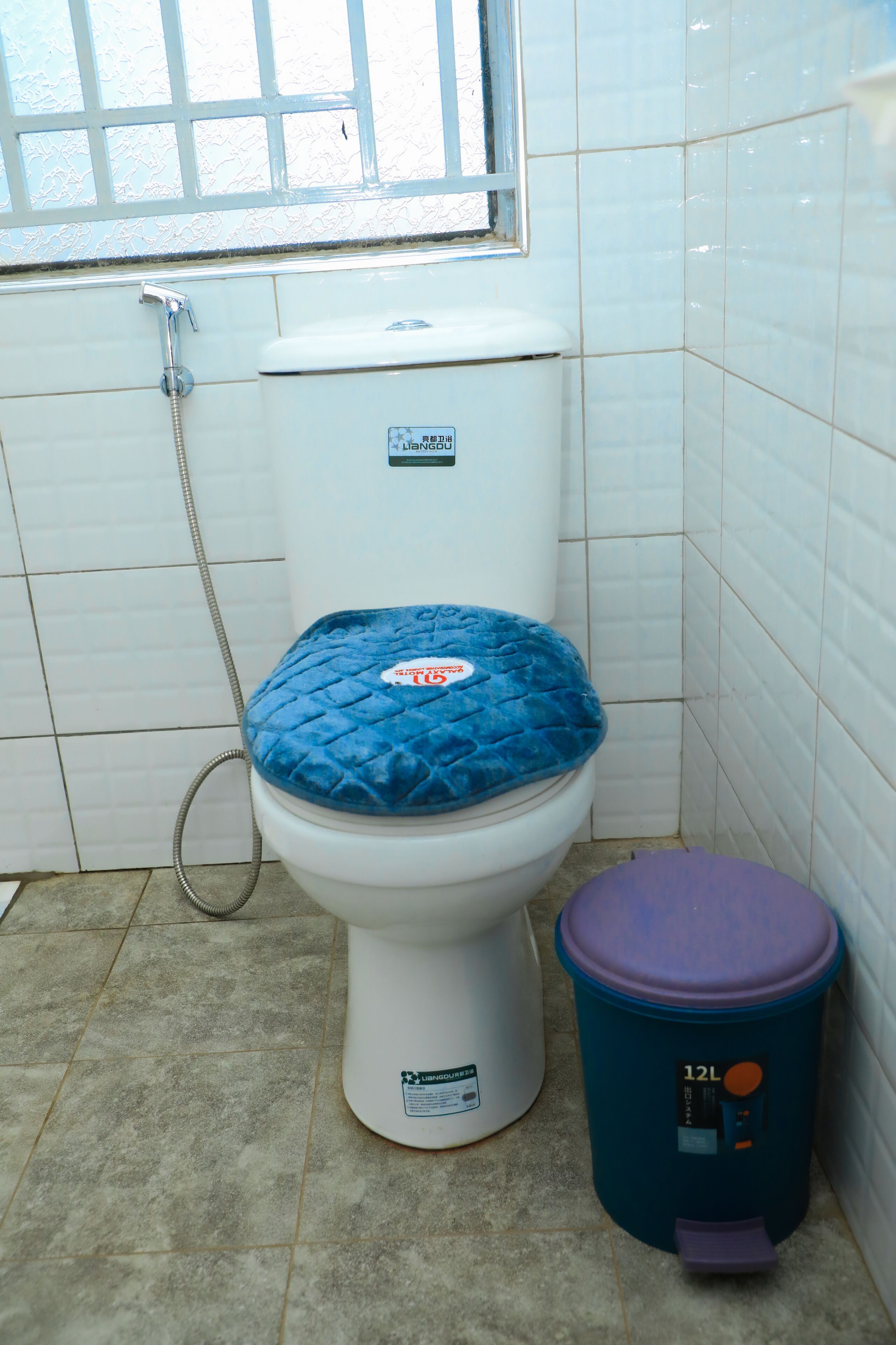 A bathroom with a toilet, a bidet, and a trash bin.