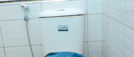 A bathroom with a toilet, a bidet, and a trash bin.